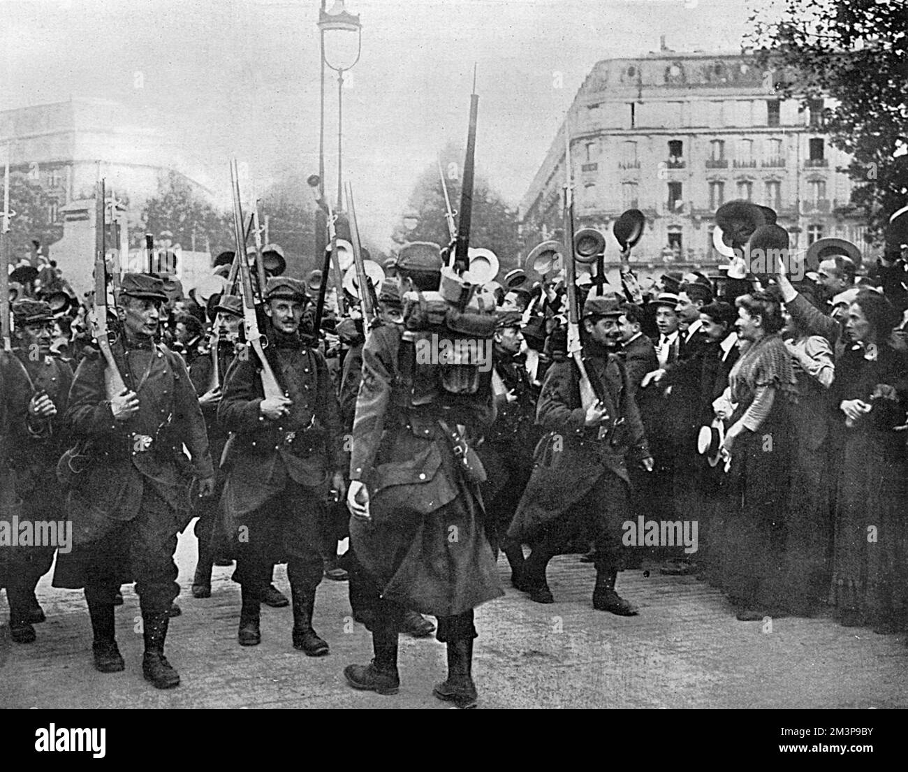 French Infantrymen are cheered on their way as they march through Paris on their way to a train station to be carried to the front line.     Date: August 1914 Stock Photo