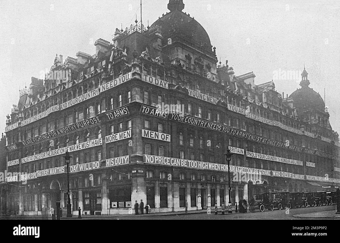 The facade of the Carlton Hotel (ceased operating in 1940), on the corner of Haymarket and Pall Mall in London, bedecked with recruiting slogans for the First World War.     Date: 1914 Stock Photo