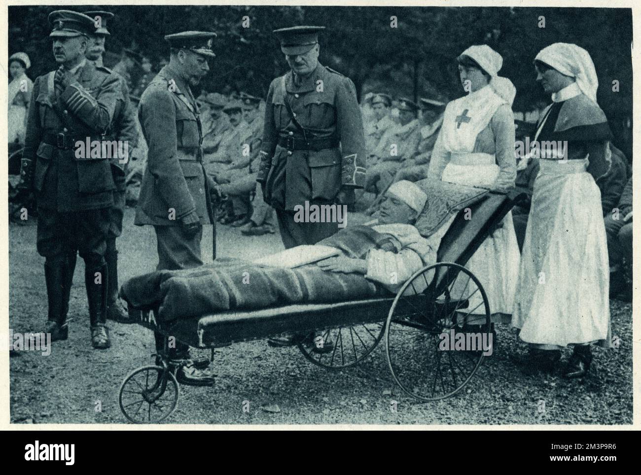 King George V accompanied with Queen Mary and Princess Mary visting the Royal Victoria Military Hospital at Netley, near Southampton in Hampshire. George V conversing with one of the wounded soldiers of World War One, in the forecourt.     Date: 30 July 1917 Stock Photo
