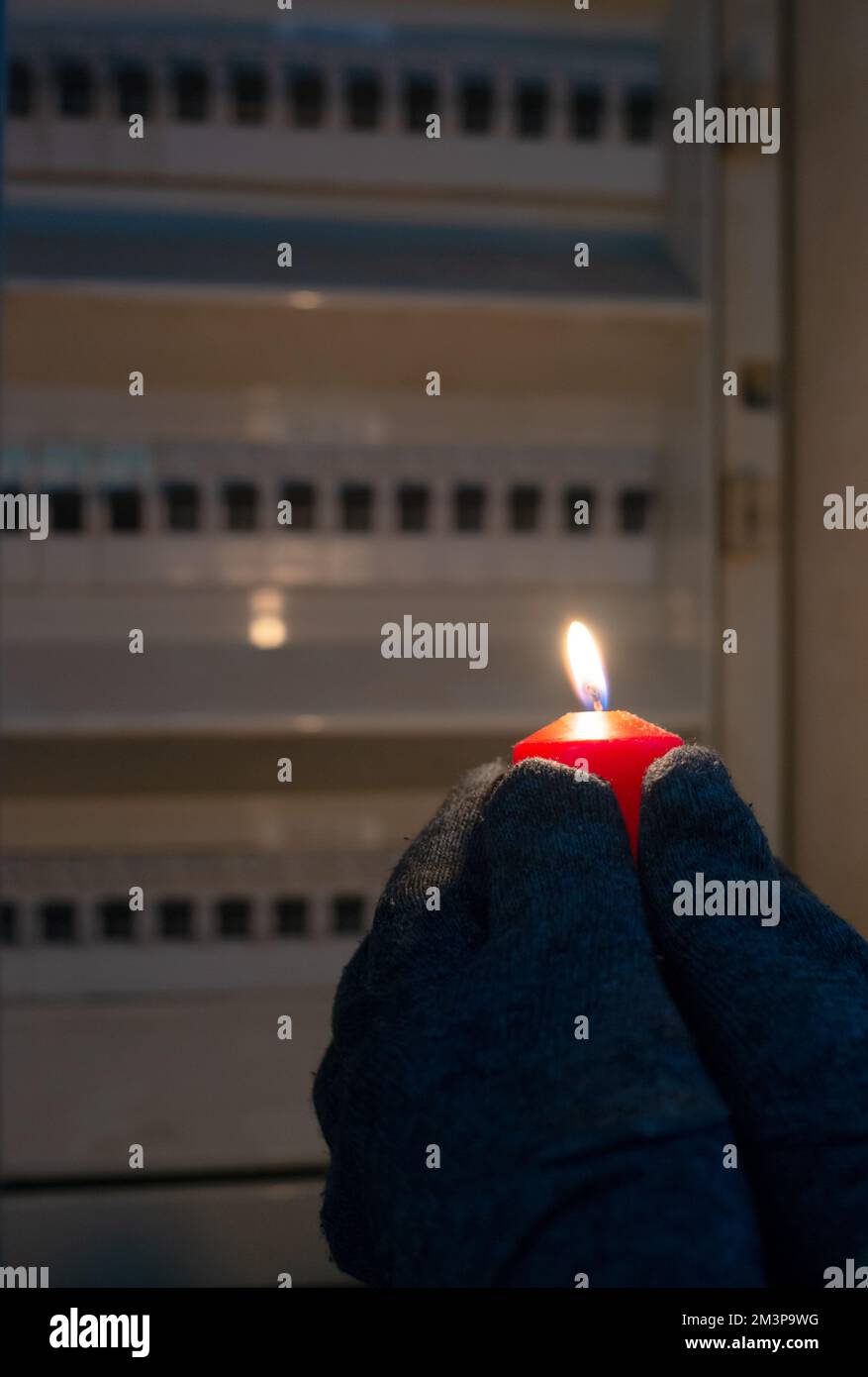Blackout, standing with a candle in front of a power fuse box, energy