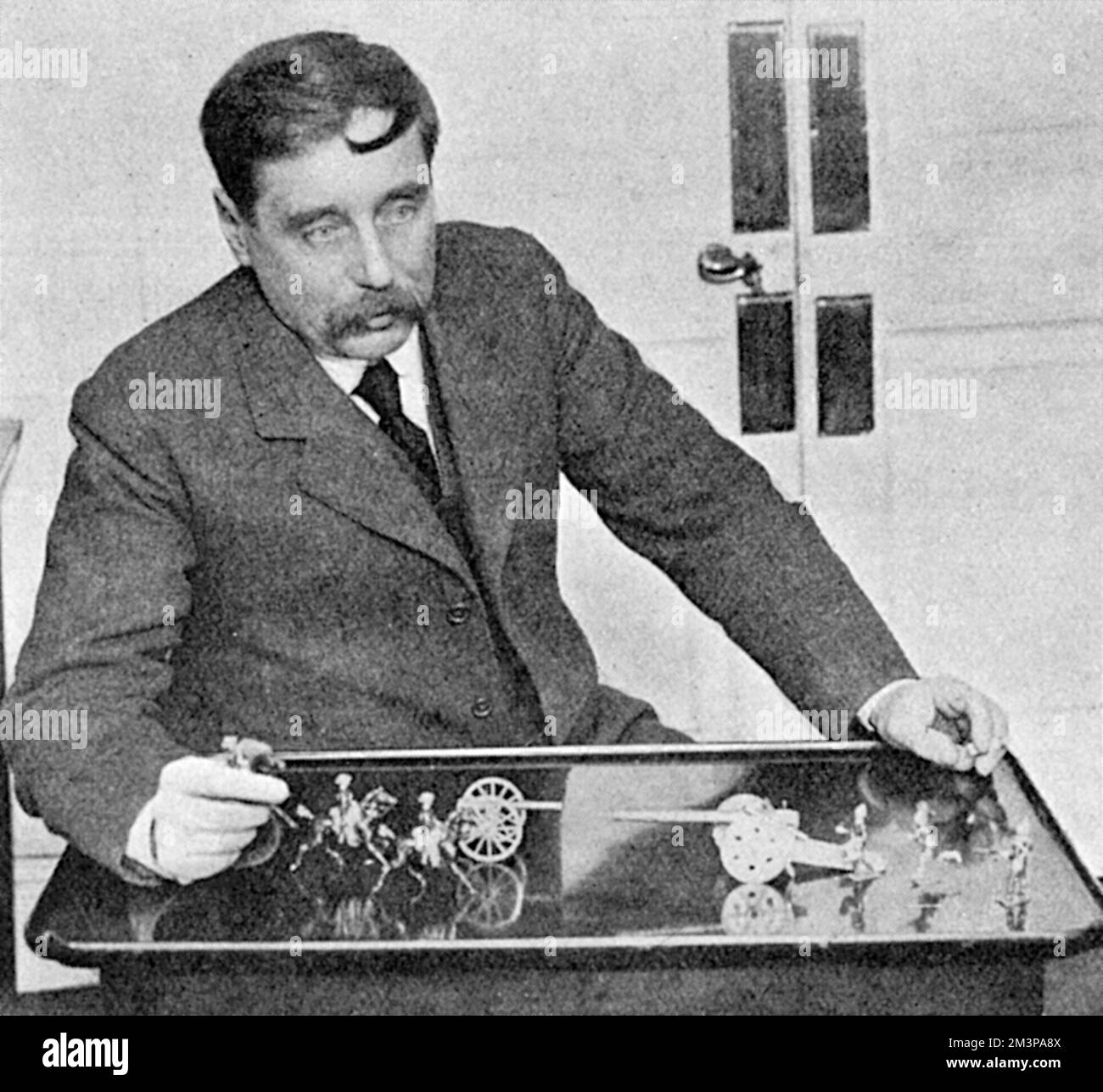 H.G.Wells playing 'Little Wars'. His book of the same name, published in 1913, described a set of rules for playing with toy soldiers, and formed the basis of hobby wargaming which is still popular today.      Date: 1915 Stock Photo