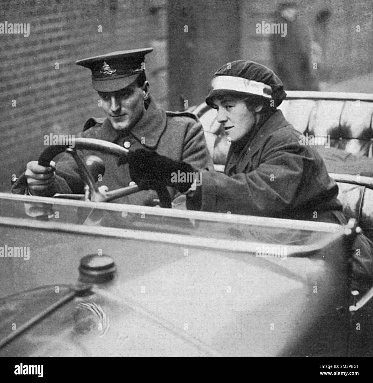A new driver in the Army Motor Transport section being taught to steer by a female instructor during the First World War. A school to teach women driving and car mechanics was established by the Hon. Gabrielle Borthwick and produced a number of women instructors who went on to teach men how to drive.       Date: 1916 Stock Photo