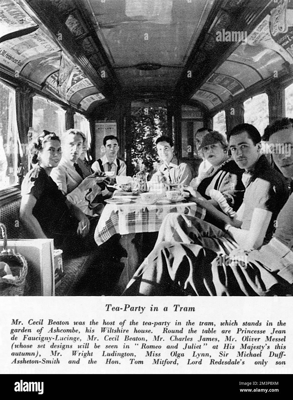 Cecil Beaton hosted a tea party in a tram which stood in his garden at Ashcombe, his Wiltshire home. Round the table are Princesse Jean de Faucigny-Lucinge, Mr Cecil Beaton, Mr Charles James, Mr Oliver Messel, Mr Wright Luddington, Miss Olga Lynn, Sir Michael Duff-Assheton-Smith and the Hon. Tom Mitford, Lord Redesdale's only son.     Date: 1936 Stock Photo