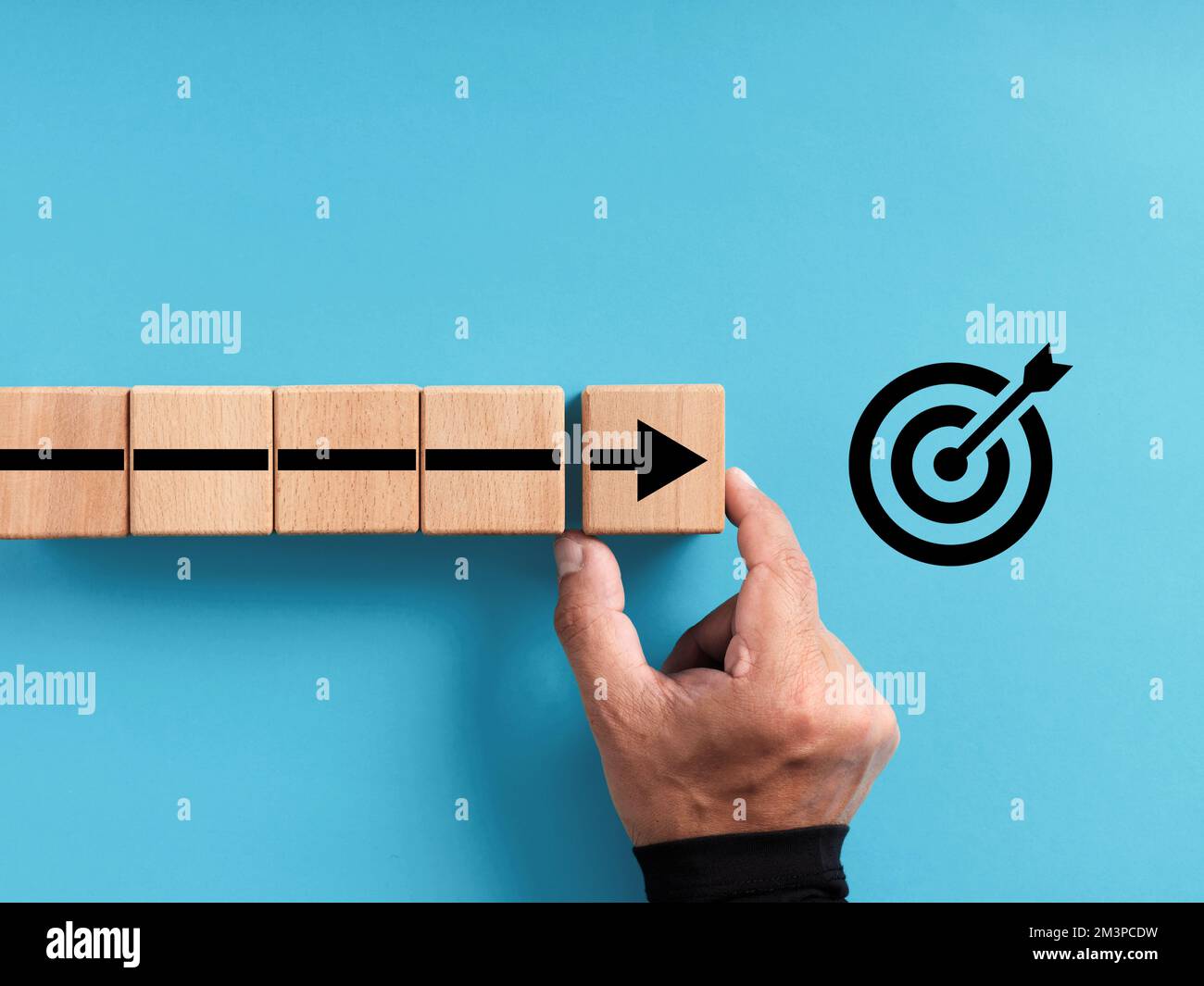 Action plan, goal setting and business development and progress concept. Achieving the goals. Hand arranges the wooden blocks with the arrow moving to Stock Photo