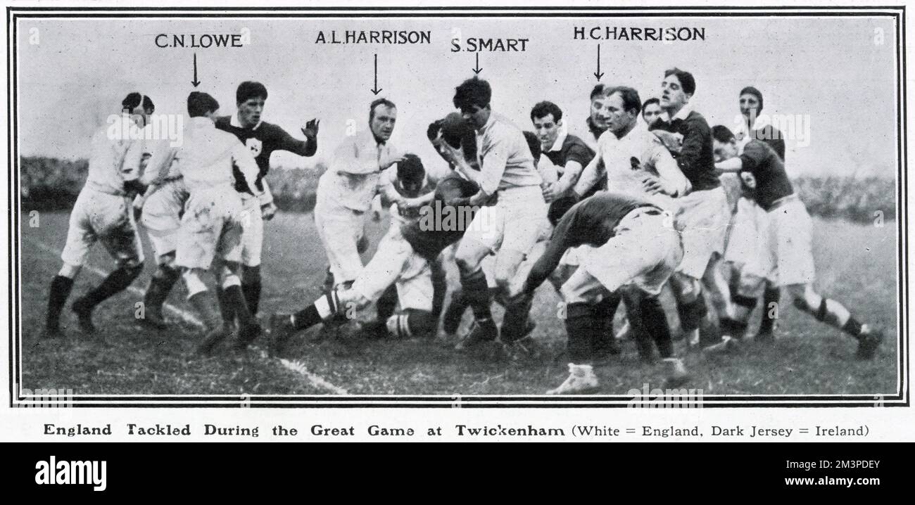 A scene from the England v Ireland rugby union match at Twickenham, won 17-12 by England, in the Five Nations Championship. The match was watched by King George V, the first time he had attended an international since his accession. Here, English players (in white) are tackled by the Irish forwards. Stock Photo