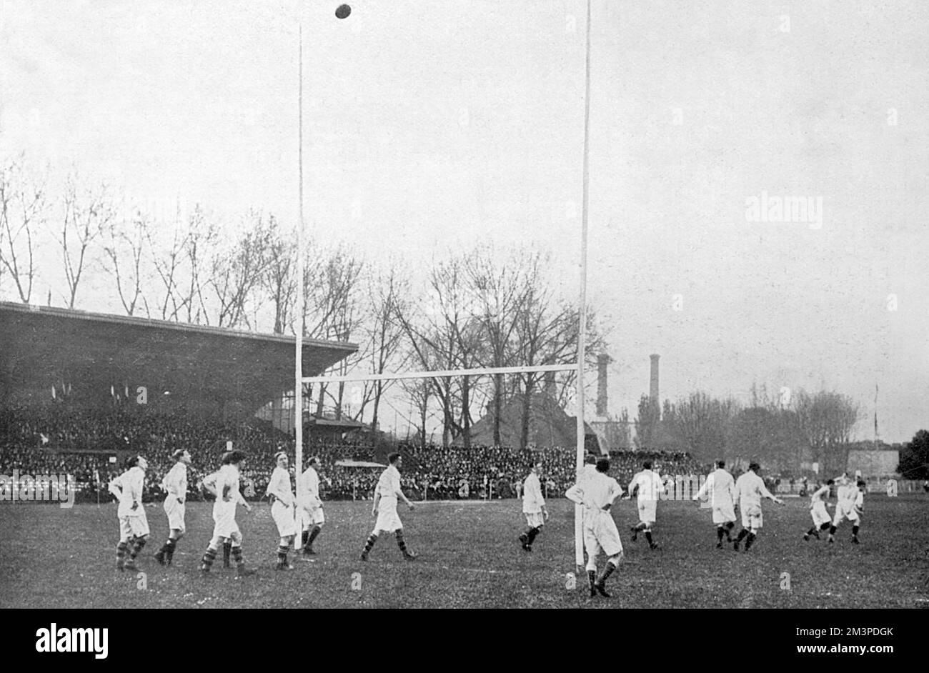 A scene from the France v England rugby union match, at Colombes, Paris. This concluding match in the Five Nations Championship of 1914 was won 13-39 by England to give them overall victory in the Championship that year. Here, the English players watch as the French successfully convert their first try.     Date: 13 April 1914 Stock Photo