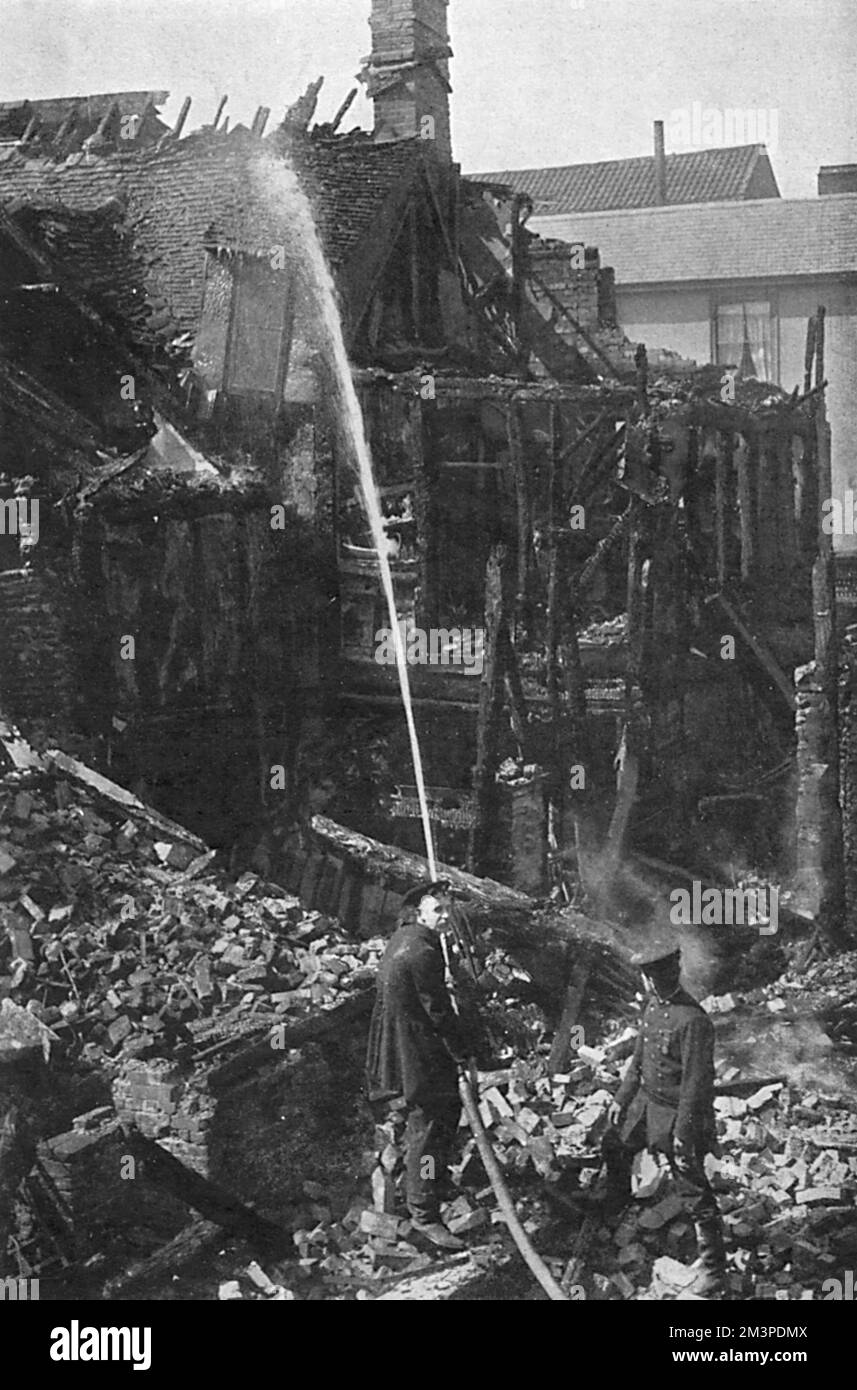 Firemen on the ruins of houses destroyed at Bury St Edmunds in Suffolk by incendiary bombs dropped in an air raid in 1915.     Date: 1915 Stock Photo