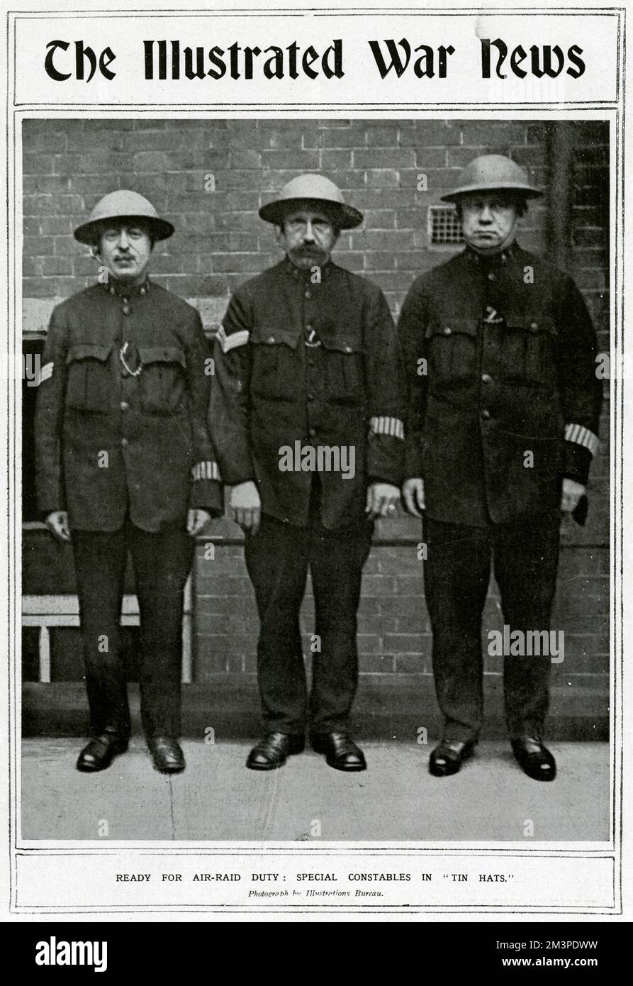 Ready for air raid duty, three special constables on the home front pose for a photograph in &quot;tin hats.&quot;     Date: 1917 Stock Photo
