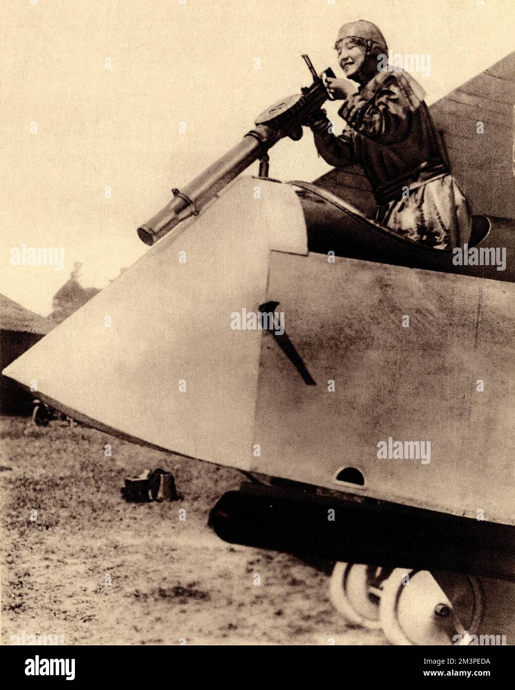 WW1 - An illustration of Mrs A. S. Hitchcock who was part of the Italian Army for expert skill in aeroplane operation. She is seen here giving a demonstration within Italian lines for a number of Americans. She manipulates the gun as if in action with an enemy plane below, showing how to handle the Lewis automatic machine-gun in an armed aircraft.     Date: 1916 Stock Photo