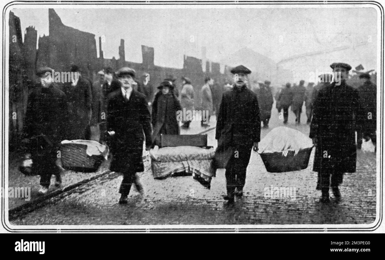 The salvage of possessions and bedding following a massive explosion at a Munitions Factory in Silvertown, East London on 19th January 1917. The Factory was producing bullets and artillery shells for the British WW1 effort and resulted in the destruction of many houses as shown here.     Date: 1917 Stock Photo