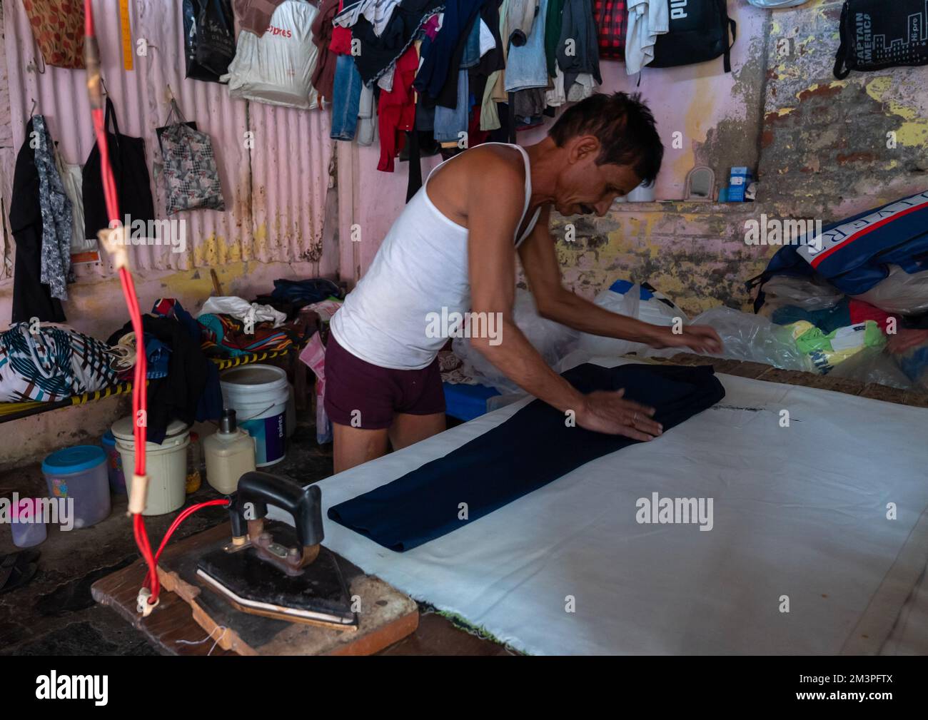 Laundry Worker ironing in Dhobi Ghat, Maharashtra state, Mumbai, India
