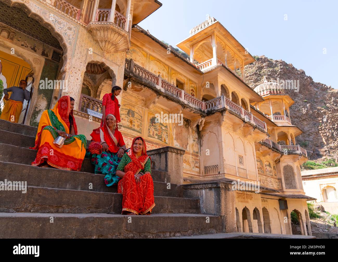 Rajasthani women sit on Galtaji temple stairs, Rajasthan, Jaipur, India Stock Photo