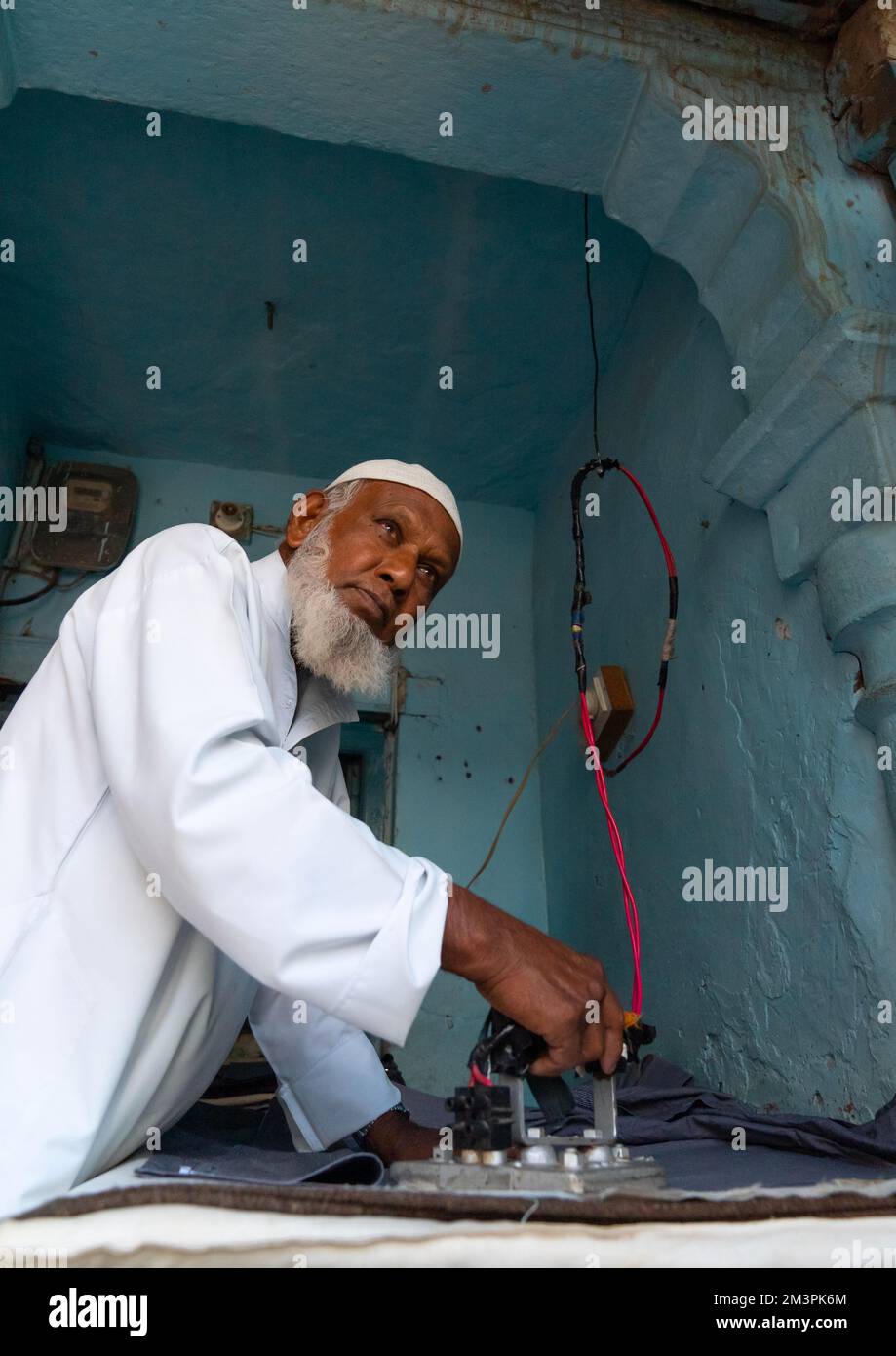 Old indian muslim man ironing clothes, Rajasthan, Ramgarh Shekhawati, India Stock Photo