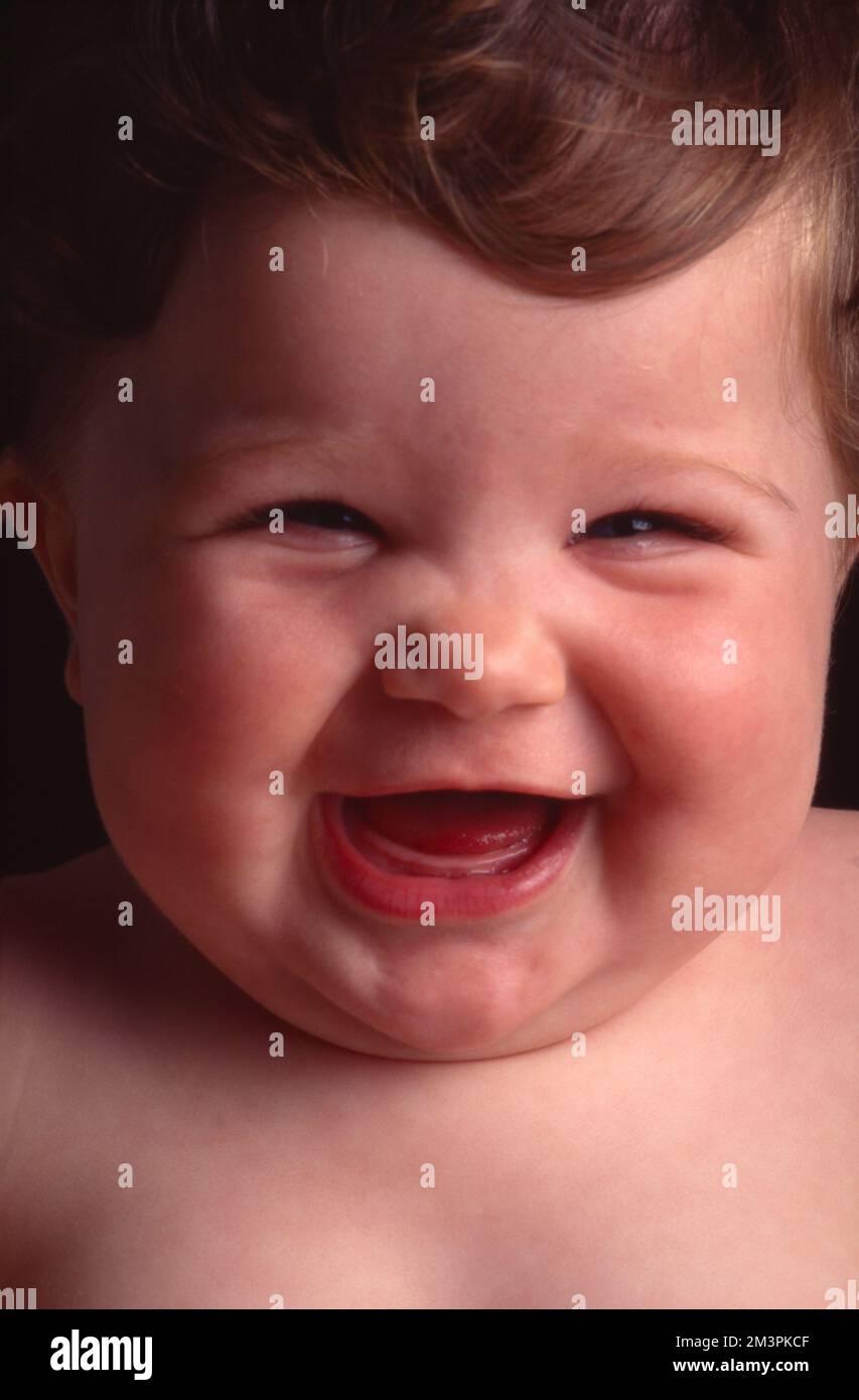 Infant, baby laughing. Eyes squinted and mouth open Stock Photo Alamy