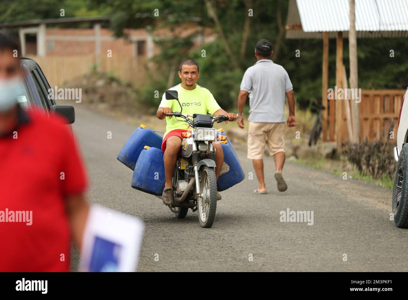 A man carrying water on 150cc motorcycle Stock Photo Alamy