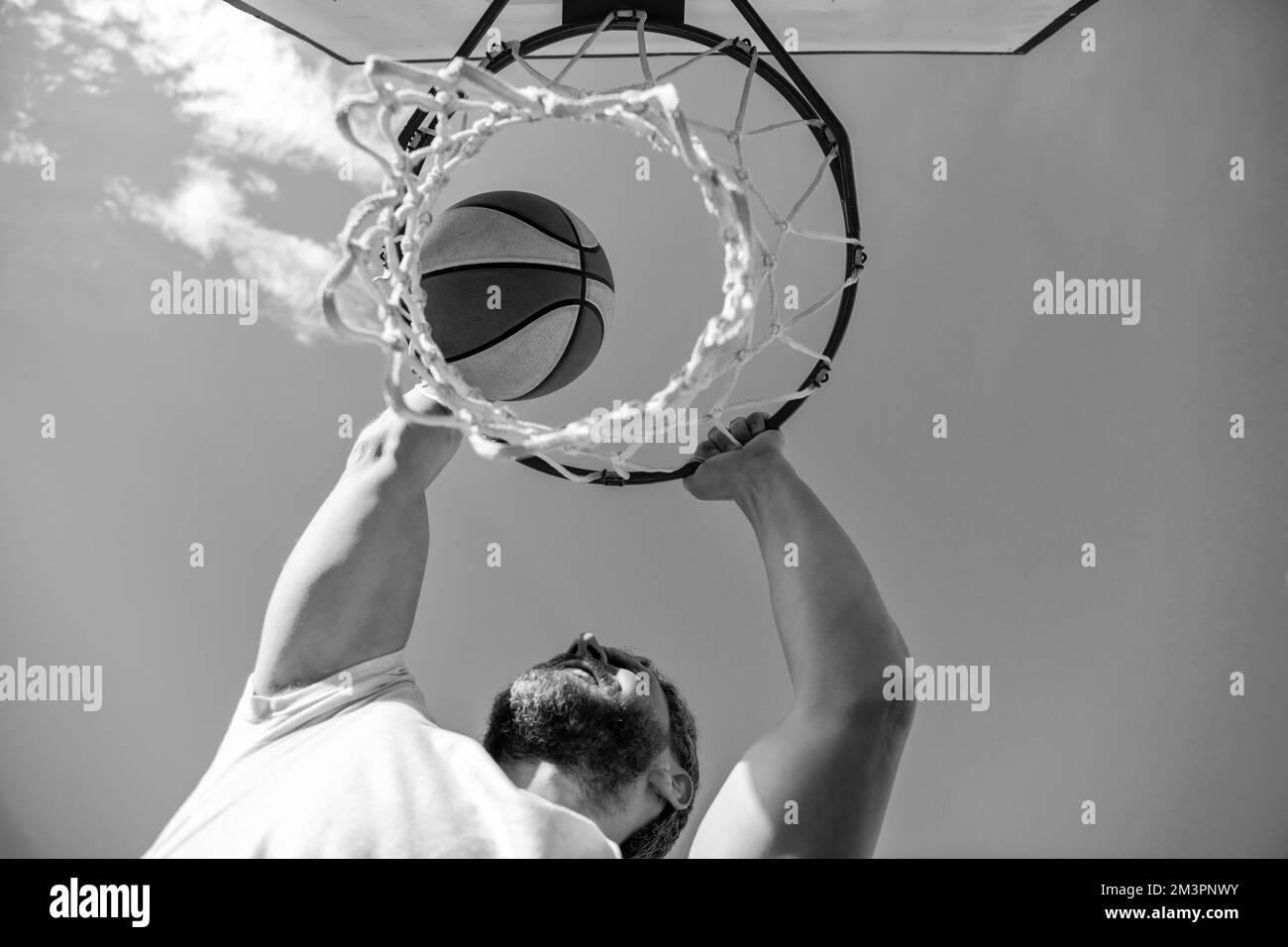 basketball player throws the ball into the hoop outdoor, targeting