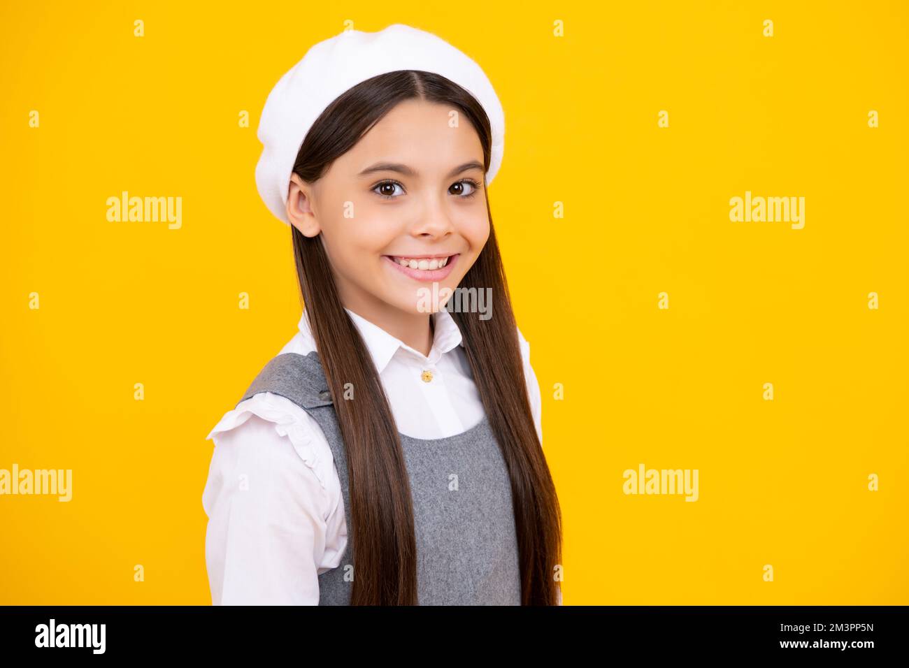Portrait of beautiful happy smiling teenage girl on yellow studio ...
