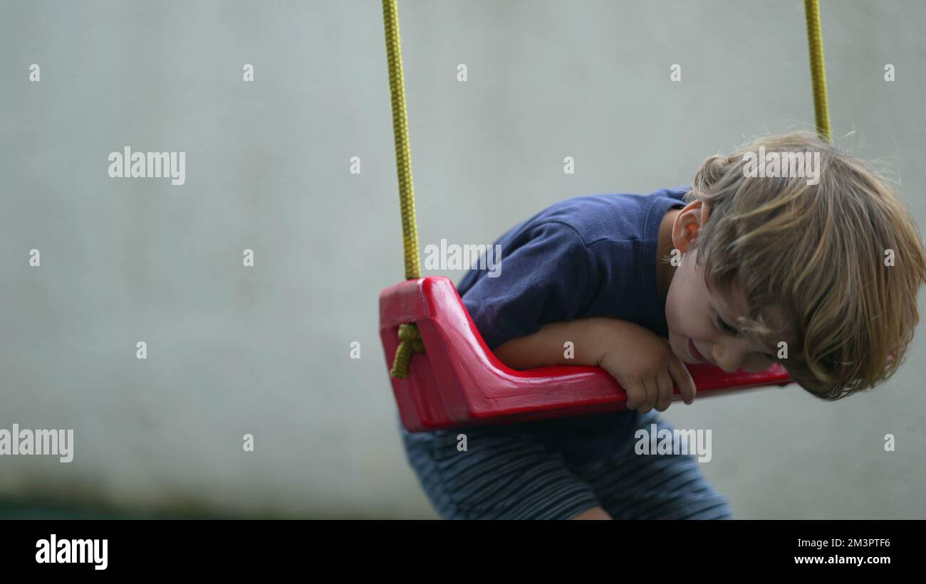 Child twisting and turning at playground swing playful little boy ...