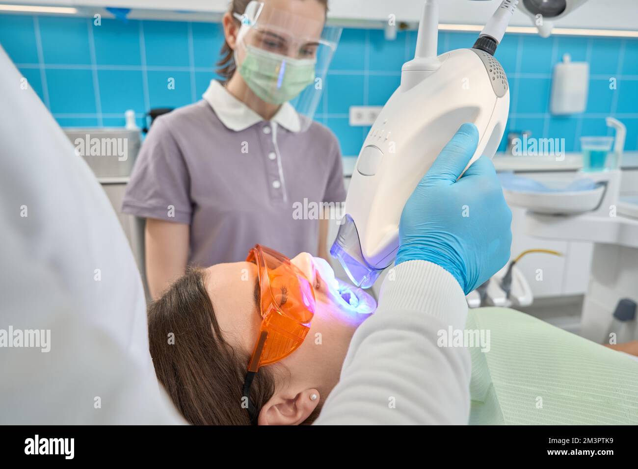 Dental hygienist doing teethwhitening procedure supervised by female nurse Stock Photo Alamy