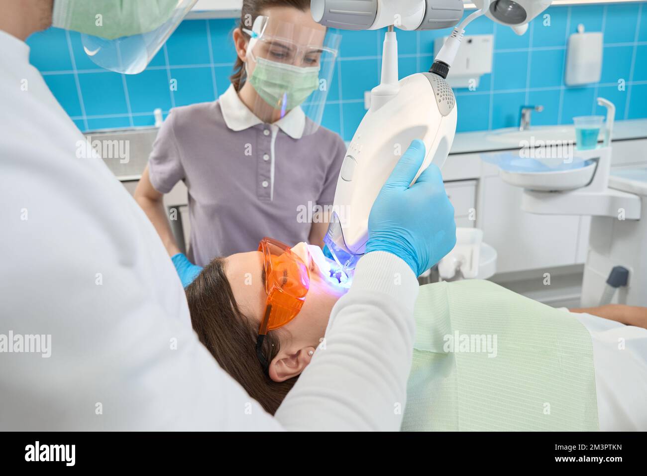 Dentist carrying out teethwhitening procedure supervised by female nurse Stock Photo Alamy