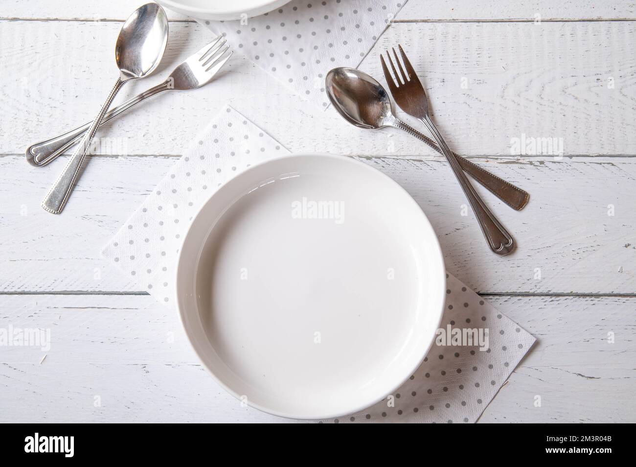 Empty white plate with fork and spoon on white background Stock Photo