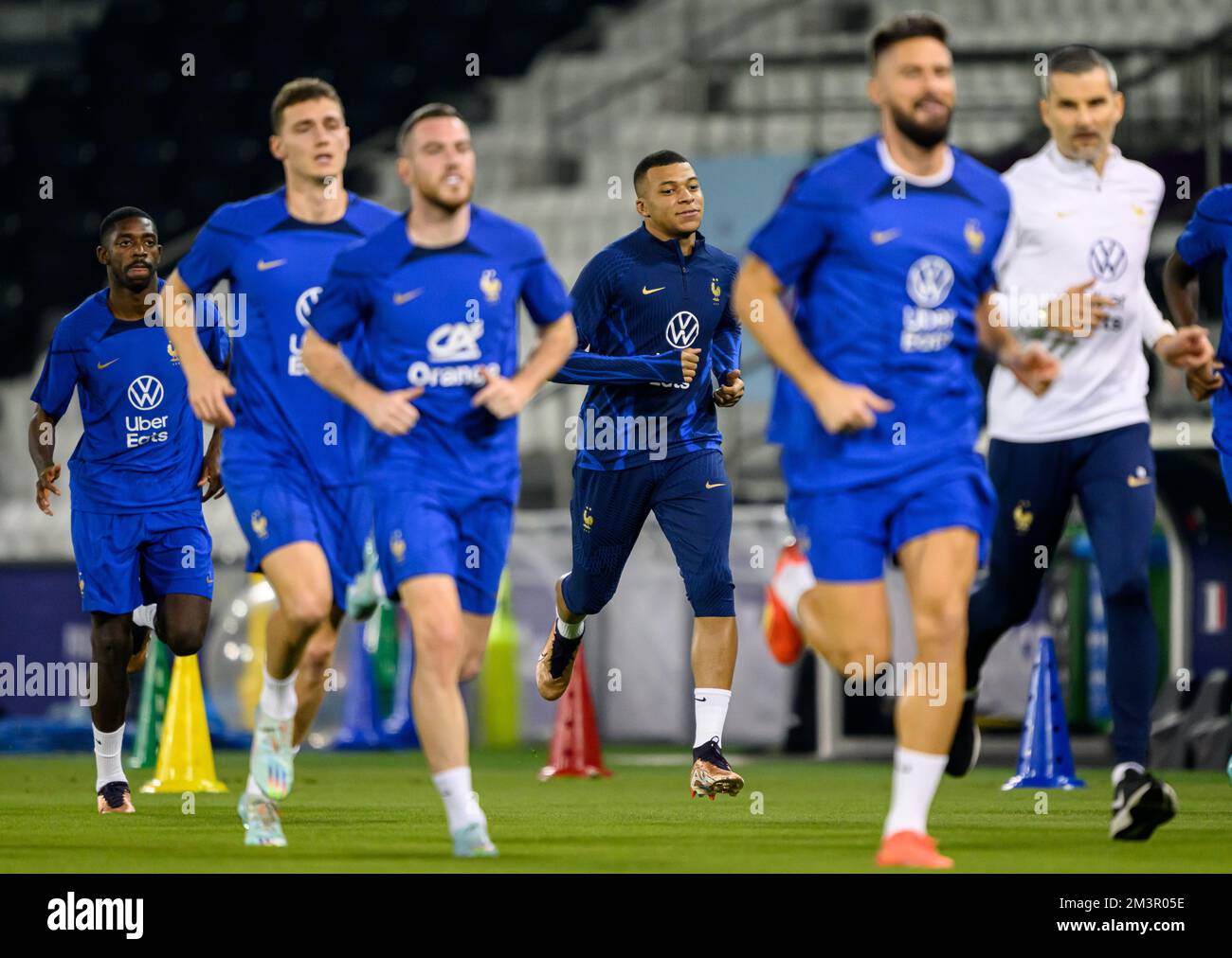 Doha, Qatar. 16th Dec, 2022. Soccer: World Cup, Before the final Argentina - France, training France at Al Sadd SC stadium. France's Kylian Mbappe (M) runs across the pitch with his teammates. Credit: Robert Michael/dpa - IMPORTANT NOTE: In accordance with the requirements of the DFL Deutsche Fußball Liga and the DFB Deutscher Fußball-Bund, it is prohibited to use or have used photographs taken in the stadium and/or of the match in the form of sequence pictures and/or video-like photo series./dpa/Alamy Live News Stock Photo