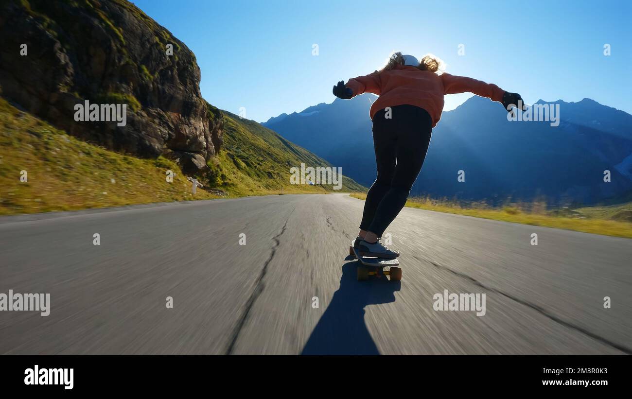 Cinematic downhill longboard session. Young woman skateboarding and