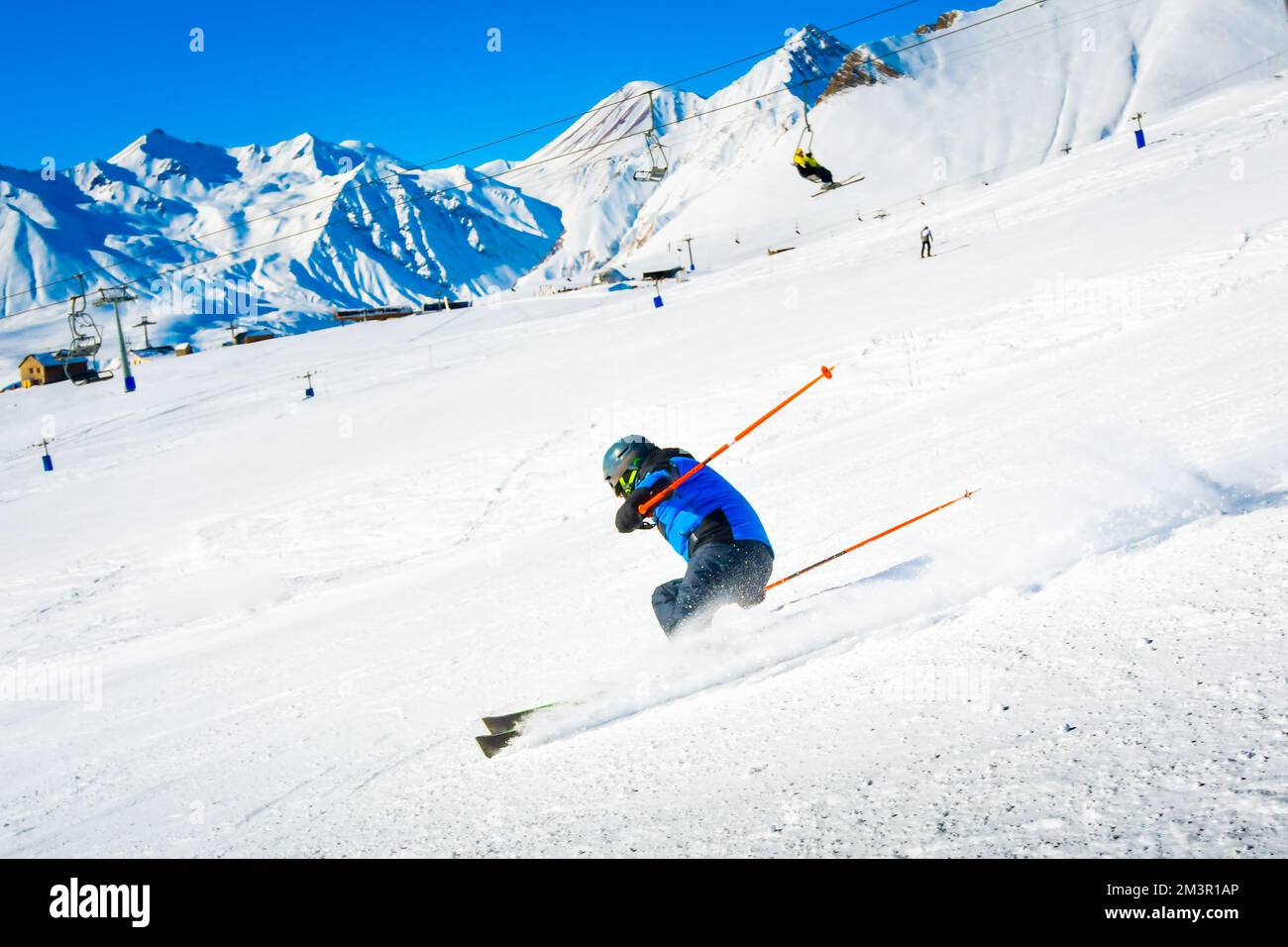 Male skier skiing downhill fast pass cabin lift in snowy conditions to