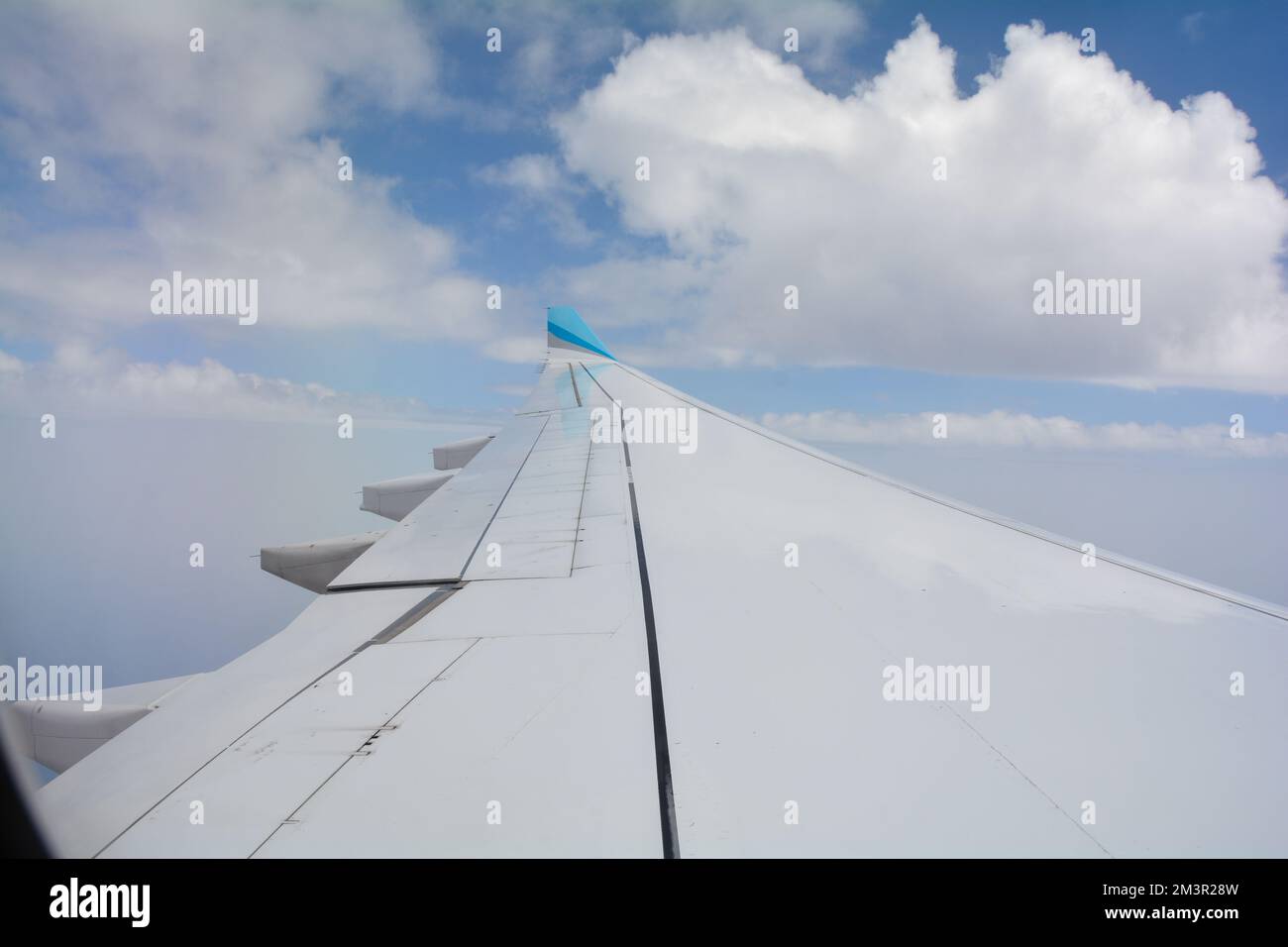 Above the clouds - wing of an airplane with blue sky Stock Photo - Alamy