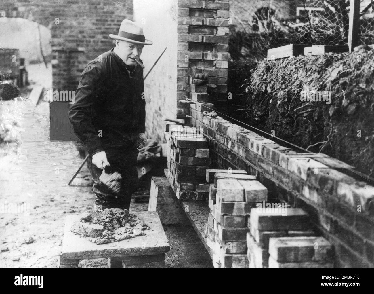 Winston Churchill bricklaying, building a wall at Chartwell in the 1930s     Date: 1930s Stock Photo
