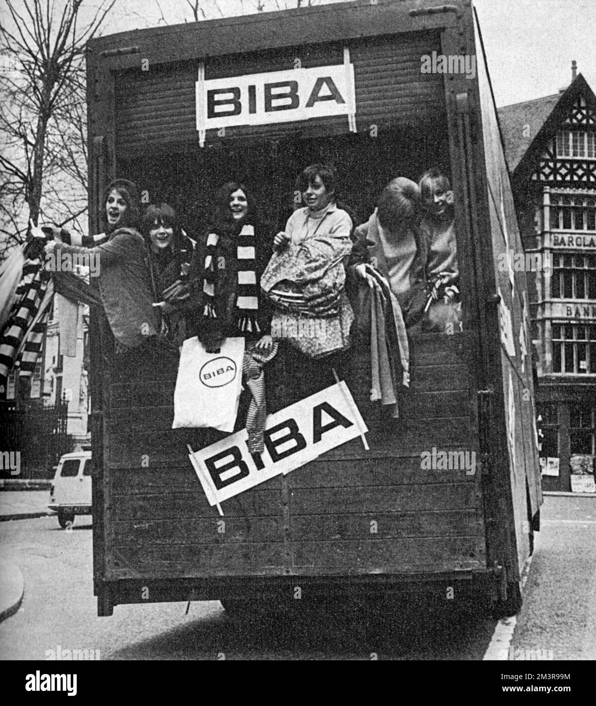 A highly publicised moving day for the Biba boutique of Barbara Hulanicki as around 60 models and well-known sixties personalities help to move the shop from its original Abingdon Road location to larger premises on Church Street.  Girls can be seen hanging out of the back of the lorry emblazoned with the Biba name.  Nicky Poulet is seen third from right.        Date: 1966 Stock Photo