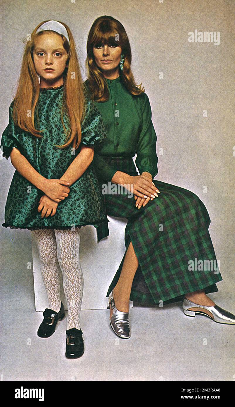 Woman wears an emerald green Irish wool shirt and matching skirt checked with purple from Laura Desmond with silver cover-up shoes from Elliott. The little girls' green dress is by Popchicks.  The buckle shoes from Harrods.       Date: 1966 Stock Photo