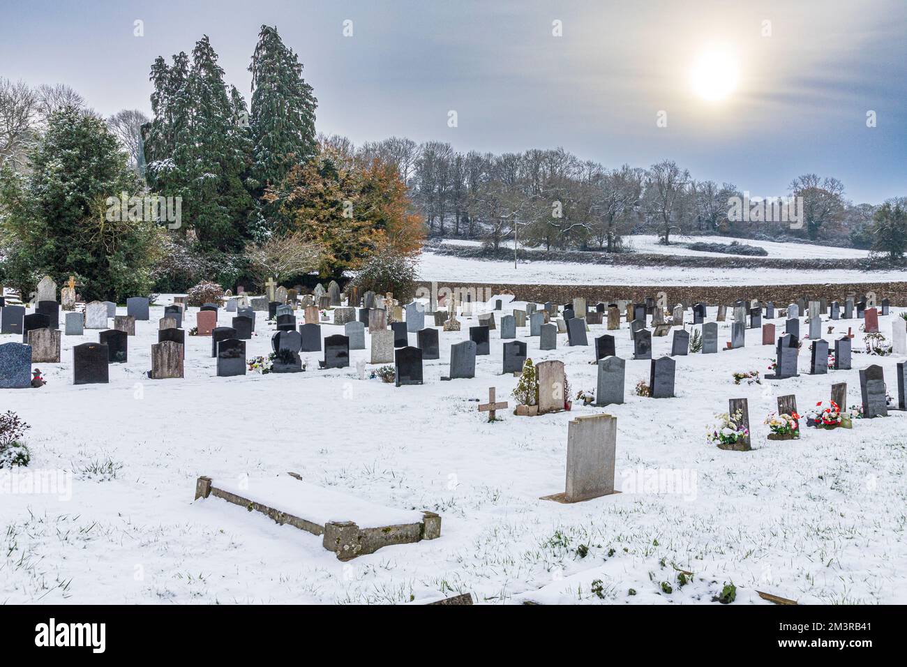 Early winter snow on the churchyard in the Cotswold hamlet of Hawkesbury, South Gloucestershire