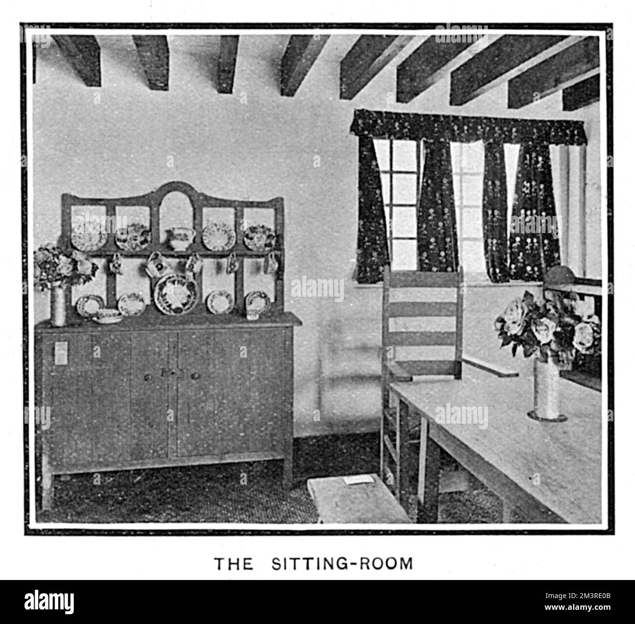 The sitting room of one of the cottages on show, furnished by Heal and Son of Tottenham Court Road.     Date: 1905 Stock Photo