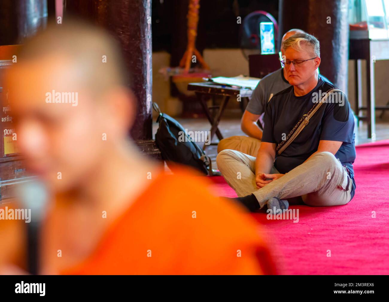 Chiang Mai, Thailand, 16/12/2022, Foreign tourists attend a prayer session to bless Thai Princess Bajrakitiyabha for her recovery during Thai Buddhist monks prays inside the Wat Phan Tao temple, in Chiang Mai. Thailand's supreme Buddhist patriarch instructed Thai monks in the kingdom and abroad to hold prayers to bless Princess Bajrakitiyabha. The Thai princess was admitted to King Chulalongkorn Memorial Hospital after she fell unconscious on the evening of 14 December 2022 due to heart related symptoms, the Bureau of the Royal Household announced on 15 December 2022. Stock Photo