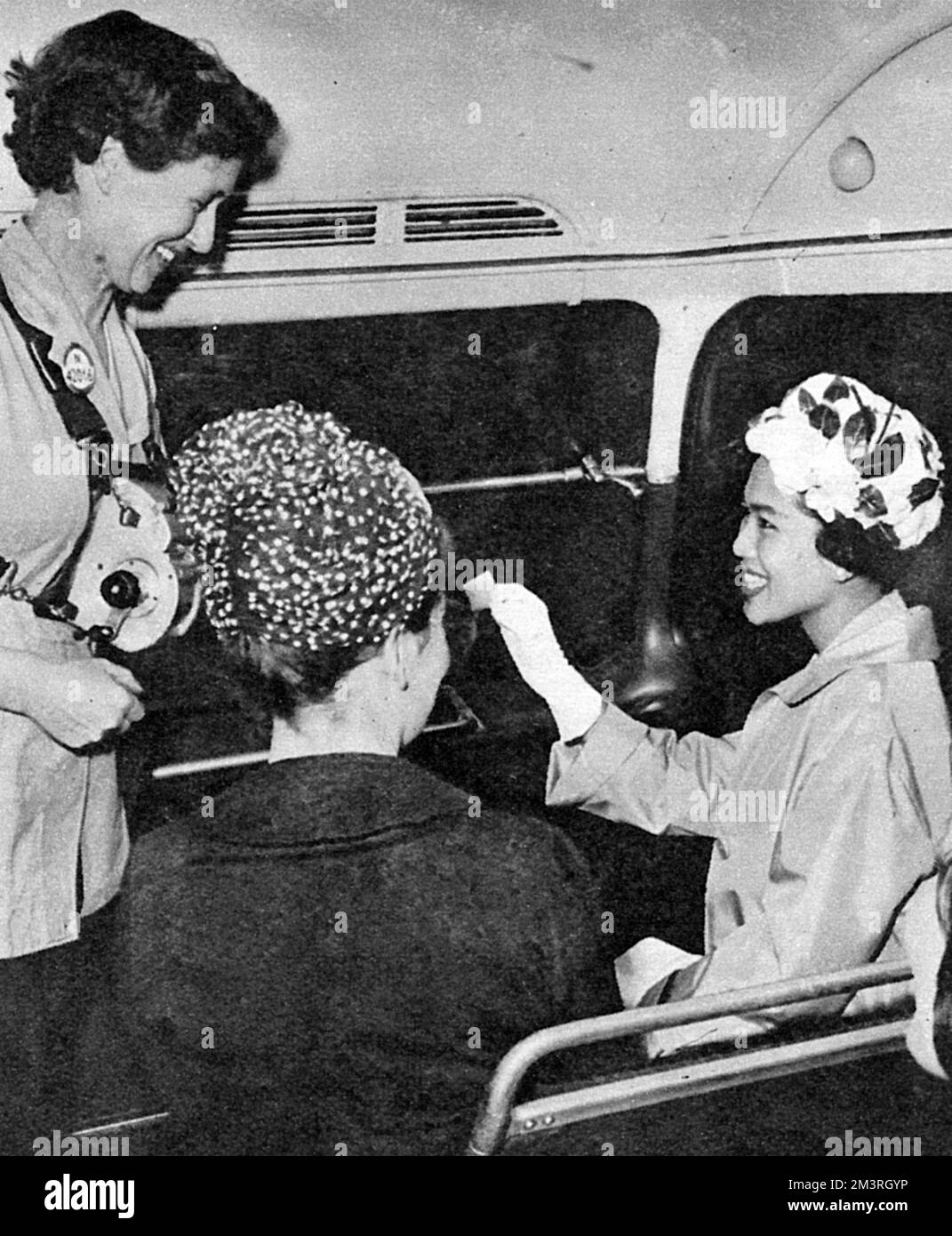 An official two-day state visit to the UK by King Bhumibol Adulyadej (Rama IX) (1927-) and Queen Sirikit (1932-) of Thailand. The Queen taking a tour of London in a London double-decker bus - she received her ticket from the conductress     Date: 1960 Stock Photo