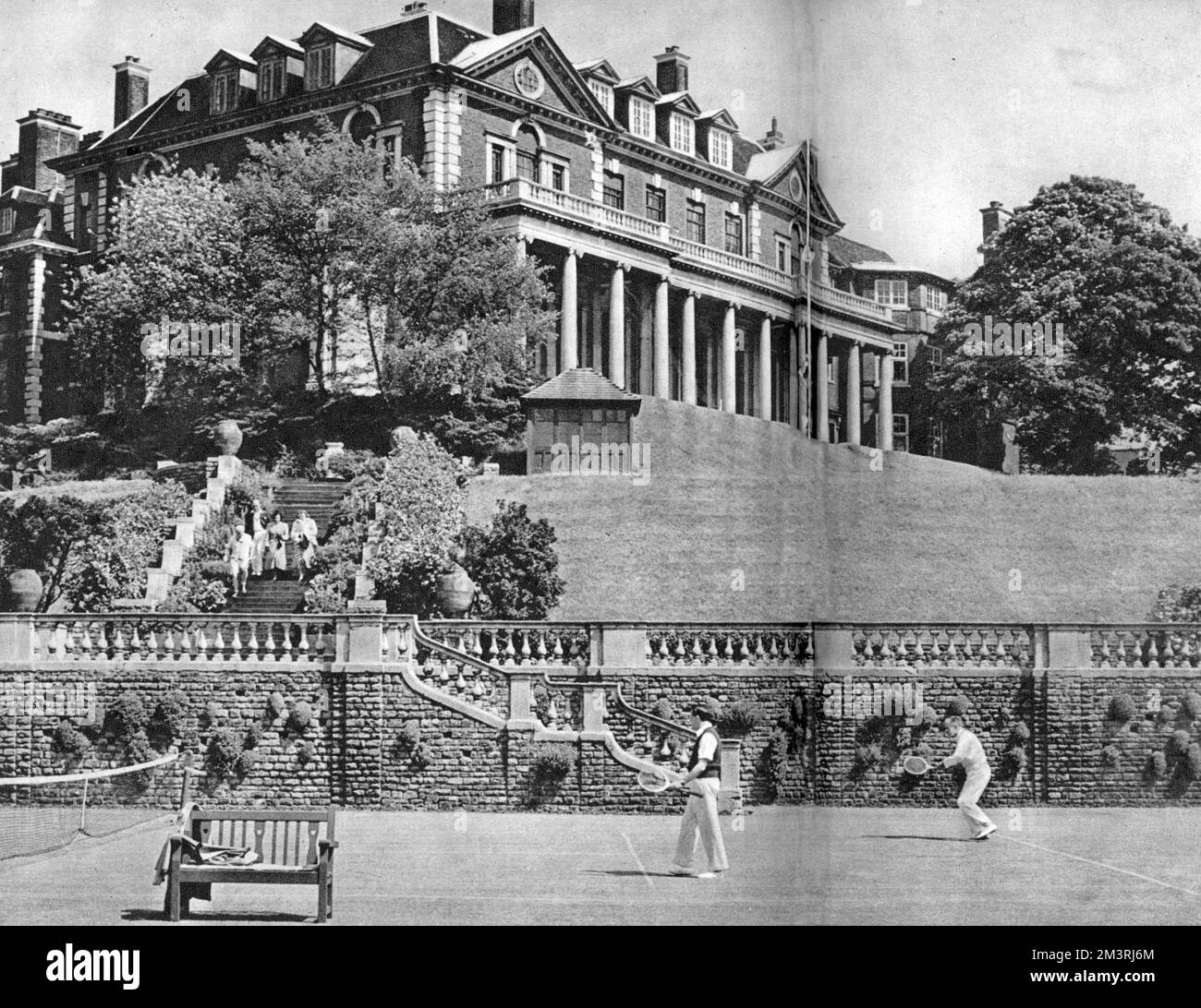 Judges playing tennis internationals at Lady Crosfield's house Witanhurst in Highate Village, north west London. Here the first fixture of the newly formed Bar Lawn Tennis Association is seen in progress, with Witanhurst in its magnificent setting above the tennis courts. The players are Mr. F. D. C Nation-Dixon and Mr. Montagu Temple, captain of the Bar Lawn Tennis Association.     Date: 1950 Stock Photo