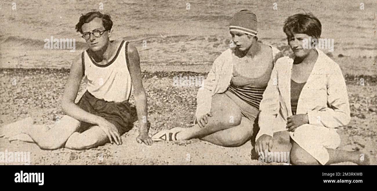Mr. Cecil Beaton, his sister, Miss Nancy Beaton, and Miss Ann Duveen, at Sandwich Bay, on the east coast of Kent.  Beaton is wearing a very fetching pair of spectacles. Sir Cecil  Beaton CBE (14 January 1904  18 January 1980) was an English fashion, portrait and war photographer, painter, interior designer and stage and costume designer for films and the theatre, best known for photographing icons including Marilyn Monroe, Twiggy and Audrey Hepburn.His sister Nancy (1909-99) was one of his earliest models.      Date: 1928 Stock Photo