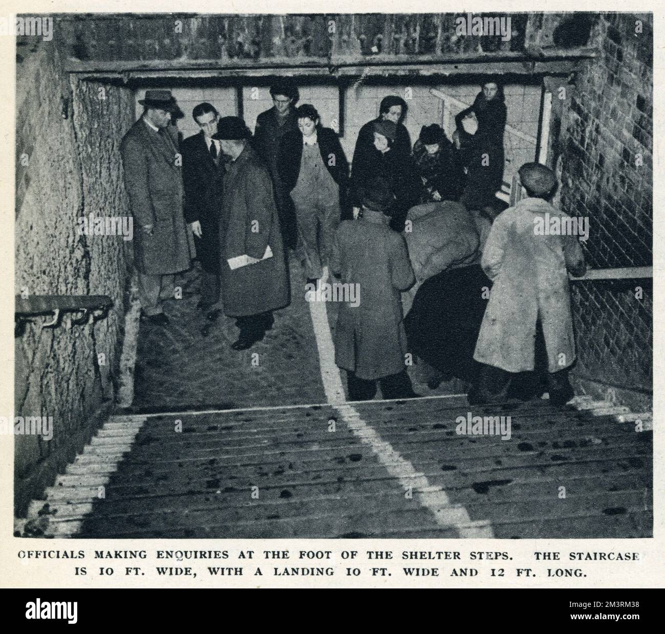 Officials making enquiries at the foot of the shelter steps.  The staircase is 10 ft. wide, with a landing 10 ft. wide and 12 ft. long.  The Bethnal Green Tube shelter disaster took place on the evening of Wednesday March 3, 1943. 1731 people died in a terrifying crush as panic spread through the crowds of people trying to enter the station's bomb shelter in the East End of London.      Date: 1943 Stock Photo