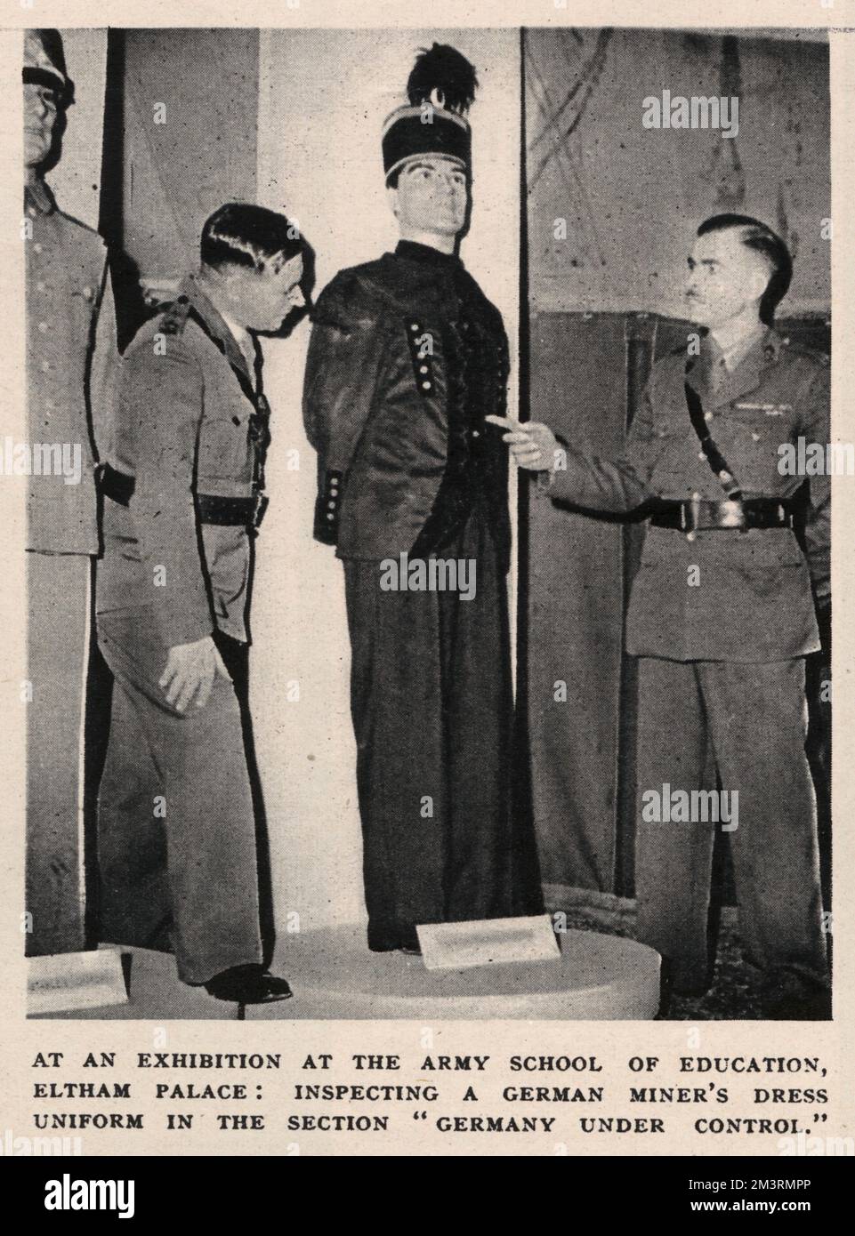 Army Education Exhibition at Eltham Palace: inspecting a German miner's dress uniform in the section &quot;Germany Under Control&quot;.     Date: 1946 Stock Photo