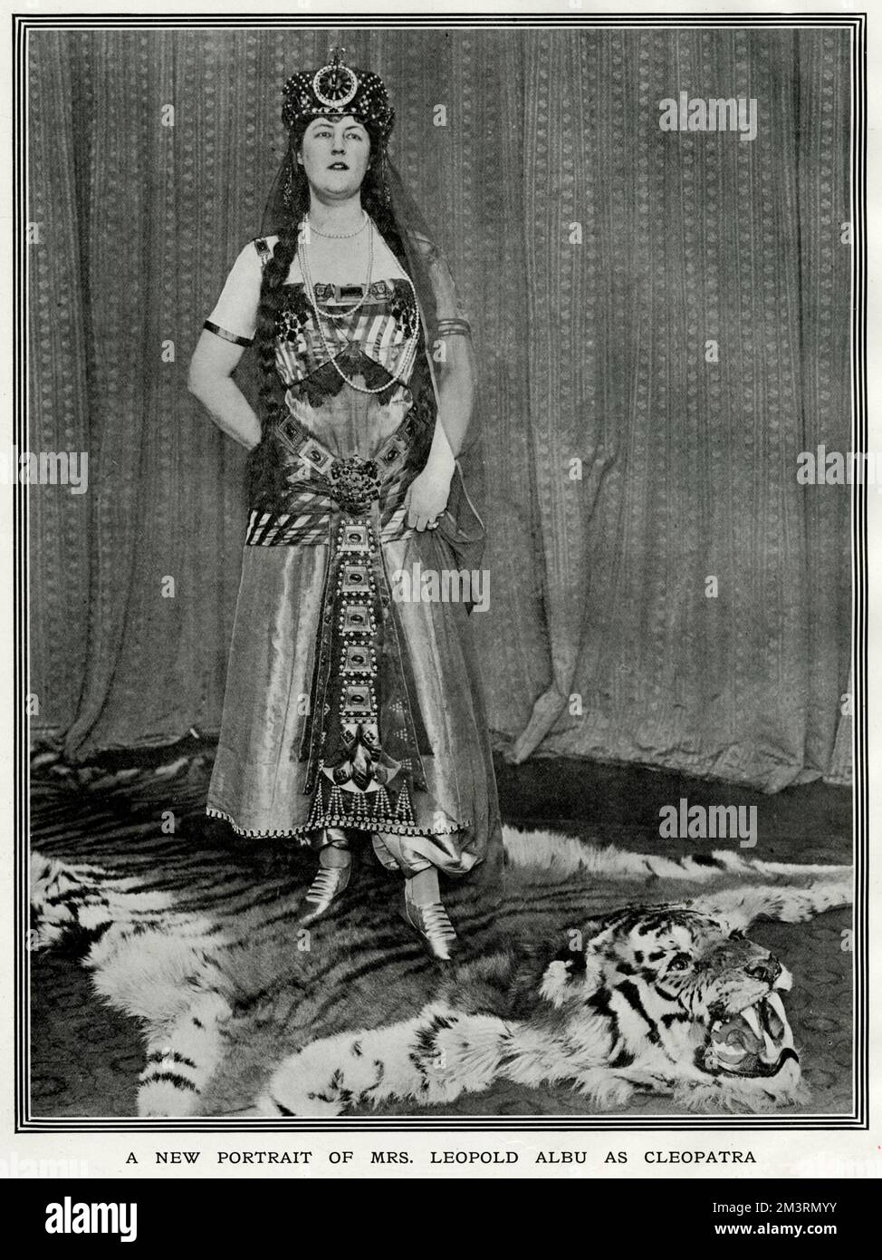Mrs Leopold Albu, formerly Adelaide Veronica Elizabeth Burton, wife of Leopold Albu, mining magnate.  Pictured in the costume she wore at a small dance she gave at 4 Hamilton Place, Park Lane in February 1912.  The Tatler remarks that she is, 'a great lover of animals' - particularly tigers by the look of the rug she's standing on.  Adelaide's marriage to Leopold ended in an acrimonious divorce in 1915.       Date: 1912 Stock Photo