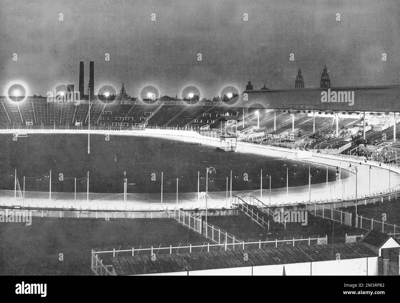 A general view at night of White City greyhound racing stadium with lights illuminated the course.  Photographed shortly after the venue had opened in response to the rising popularity of the spectator sport in the UK.     Date: 1927 Stock Photo