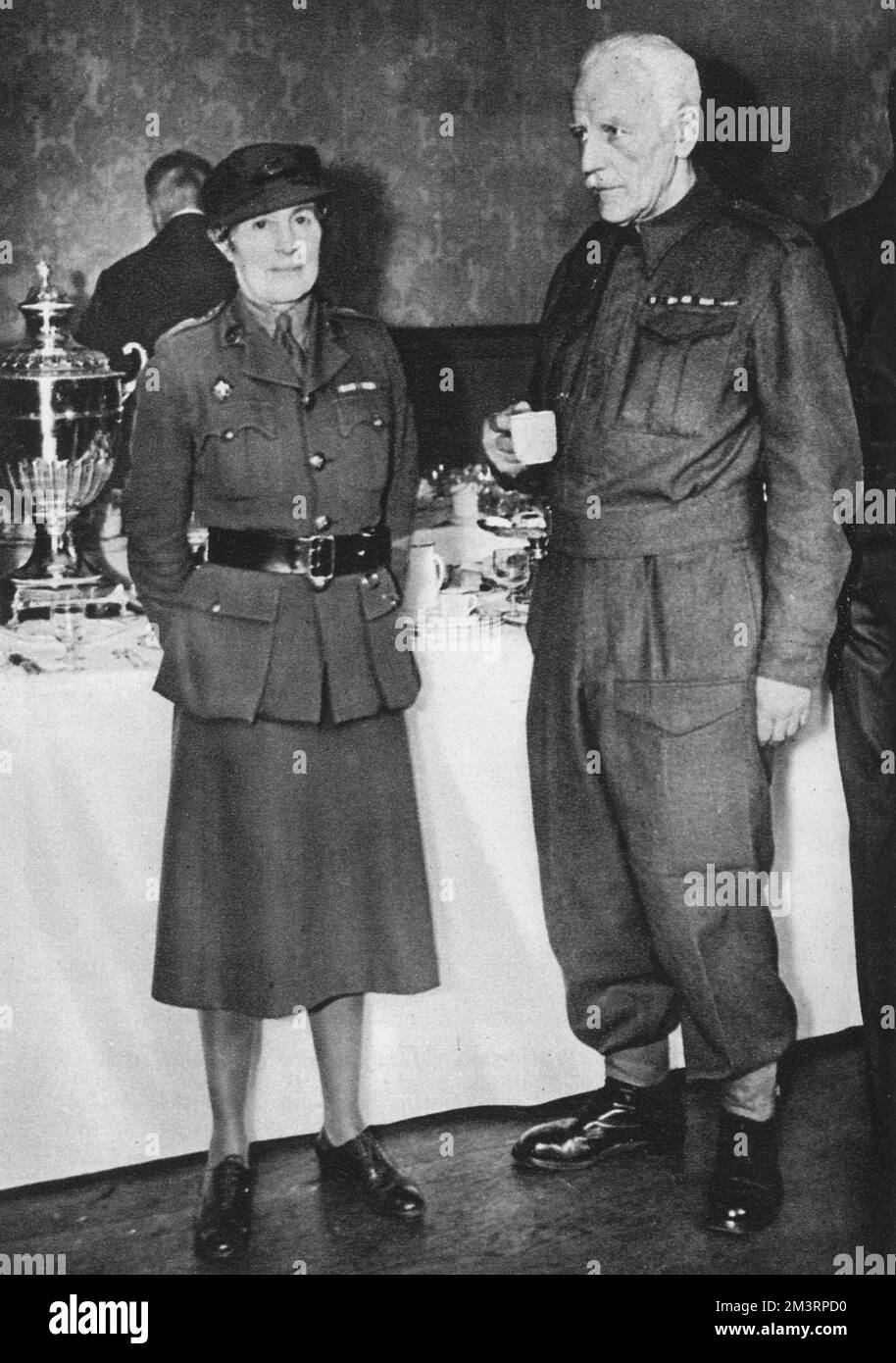 David Bertram Ogilvy Freeman-Mitford, 2nd Baron Redesdale (13 March 1878  17 March 1958), pictured in Home Guard uniform at the wedding of his youngest daughter, Deborah (Debo) to Lord Andrew Cavendish in 1941.  He is standing next to his sister-in-law by marriage, Mrs G. Bowles. The wedding reception was held at the Redesdales' London home, 26, Rutland Gate.  Lord Redesdale was known by his six daughters, the famous Mitford Sisters, as Farve.     Date: 1941 Stock Photo