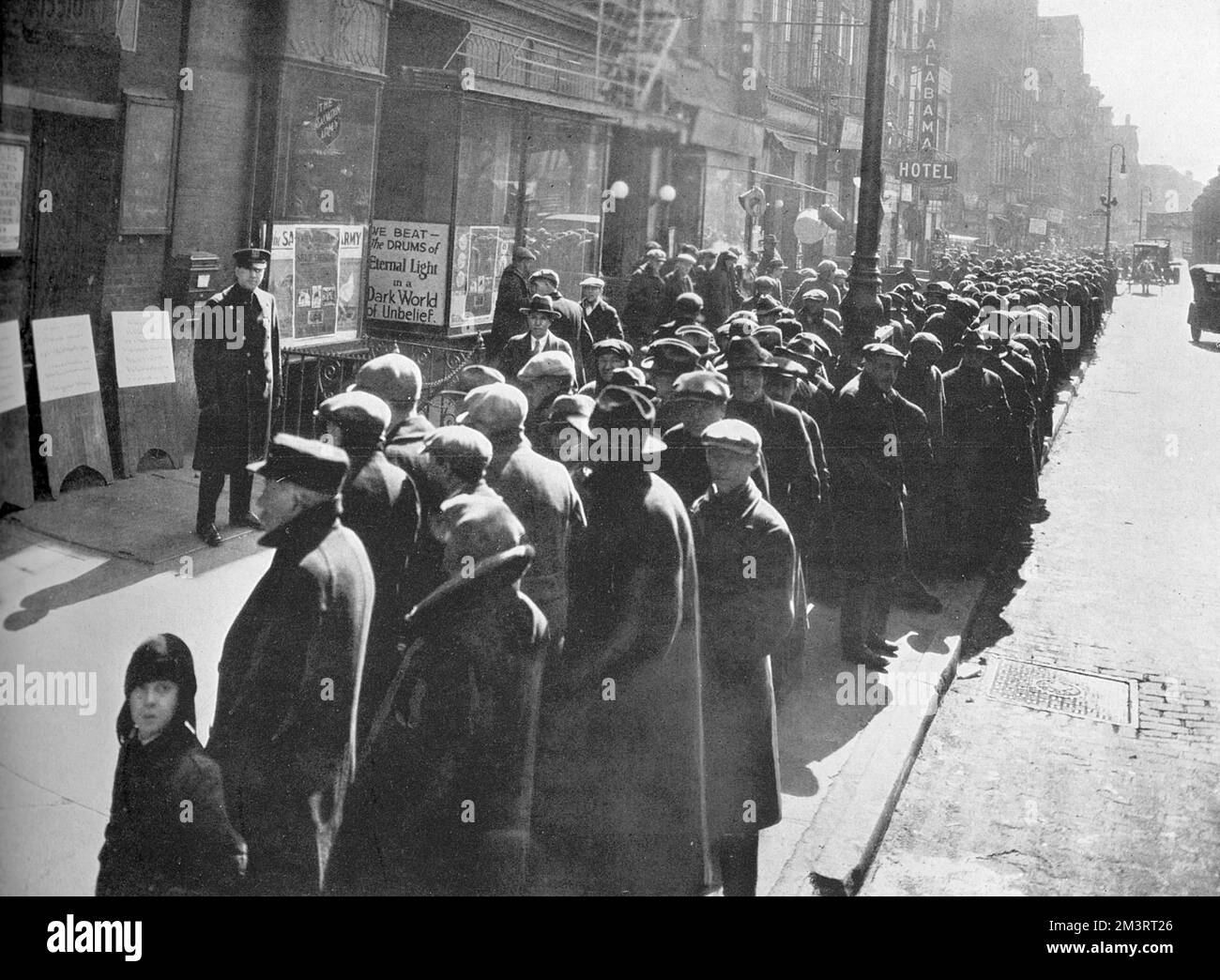 A long line of down and outs waiting at the doors of the Mission in the Bowery district of New York, where 1200 destitute men were given free food and coffee every day.  Signs of economic downturn in prosperous America a year before the stock market crash of 1929 would result in the Great Depression.    1928 Stock Photo