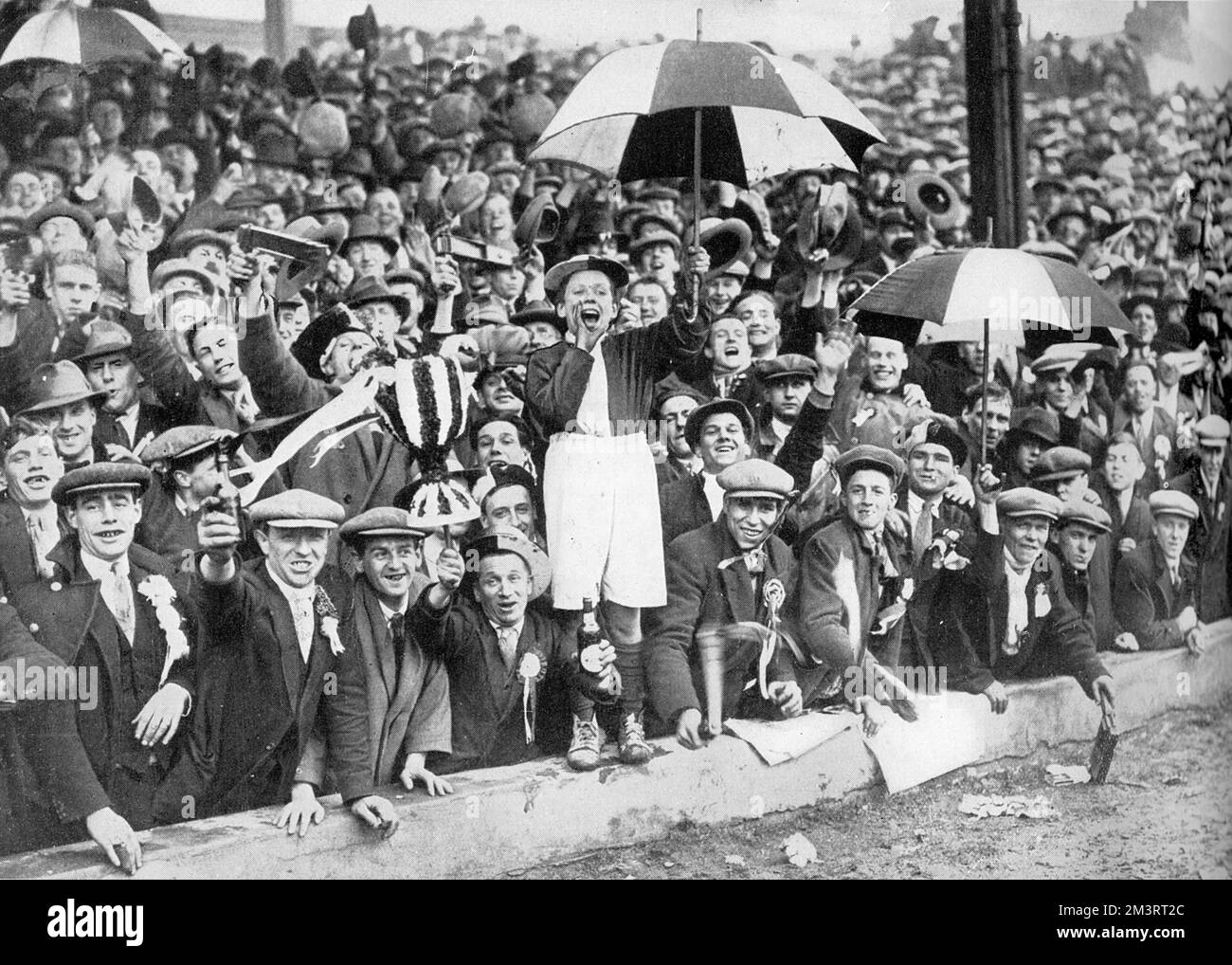 A jolly crowd of football fans at the Leicester ground for the semi-final of the Football Association cup between Blackburn Rovers and Arsenal in March 1928.  According to The Graphic, &quot;The uproar when Arsenal were beaten by 1-0 could have been heard over half the shire, and was echoed in the crowded trains which bore the disappointed supporters of the London team home.&quot;  It being 1928, football crowds comprised almost exclusively of men, as evidenced in this photograph.    1928 Stock Photo