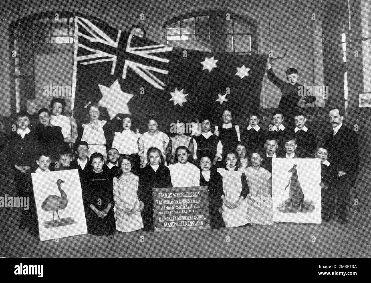 A flag sent to the boys and girls of Blackley Municipal School, Manchester by the pupils of Wellington Road School, Adelaide and unfurled on Empire Day by Sir Frederick Cawley, Liberal M.P. for the Prestwich division of SE Lancashire.  The pictures of the kangaroo and emu are watercolours painted by Mr. W. Webster Hoare, an old colonial artist.  Empire Day was instigated by the Earl of Meath and celebrated on Queen Victoria's birthday, May 24th each year.  The day was focused on children and aimed to educate them about the Empire and emphasise the bonds between nations within the British Empir Stock Photo