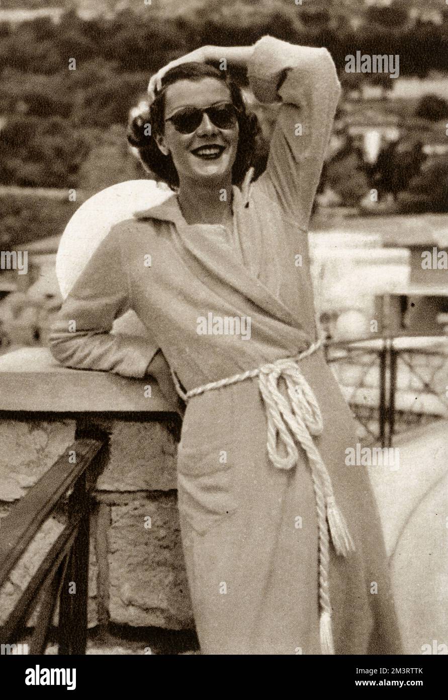 Society beauty, the Countess of Warwick, wife of the seventh Earl and formerly Miss Rose Bingham (later Mrs Billy Fiske), pictured in a yellow beach robe on Monte Carlo Beach.  The Bystander reports she had been staying at Antibes.       Date: 1938 Stock Photo