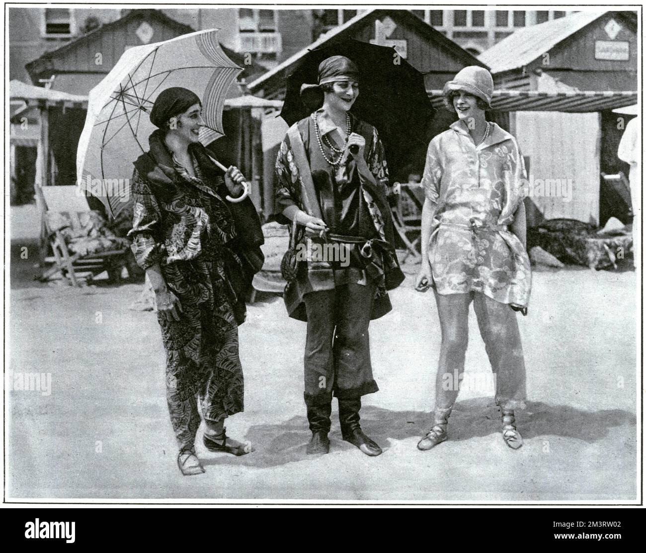 High society enjoying the pleasures of life at the Venice Lido while being dressed entirely appropriately in beach pyjamas.  From left, Countess Beatty, the Duchess of Sutherland and Lady Ednam.  It was de rigeur to wear 'beach negligees' or pyjamas, brightly patterned, coordinating ensembles in lightweight fabrics.  The Sketch magazine gives special mention to the Duchess's Russian style boots.     Date: 1924 Stock Photo