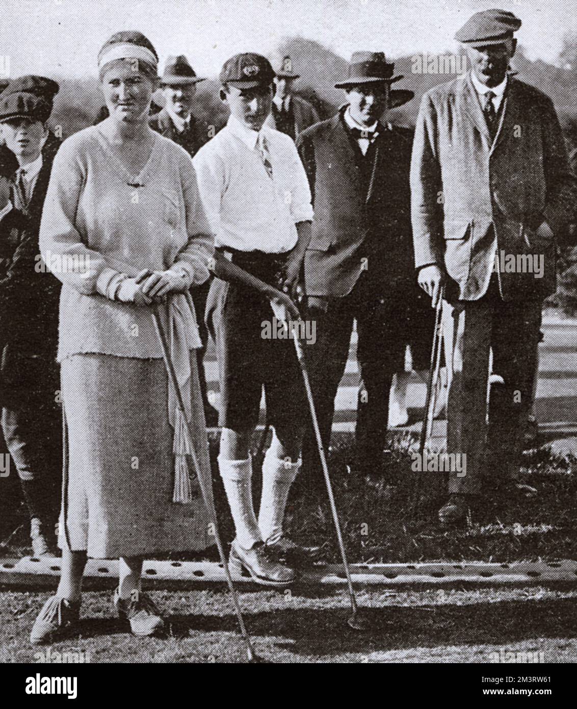 Miss Winifred Sarson and Master Donald Mathieson, competitors in the Boy and Girl Golf Championships at Walton Heath being watched by club professional James Braid.      Date: 1921 Stock Photo