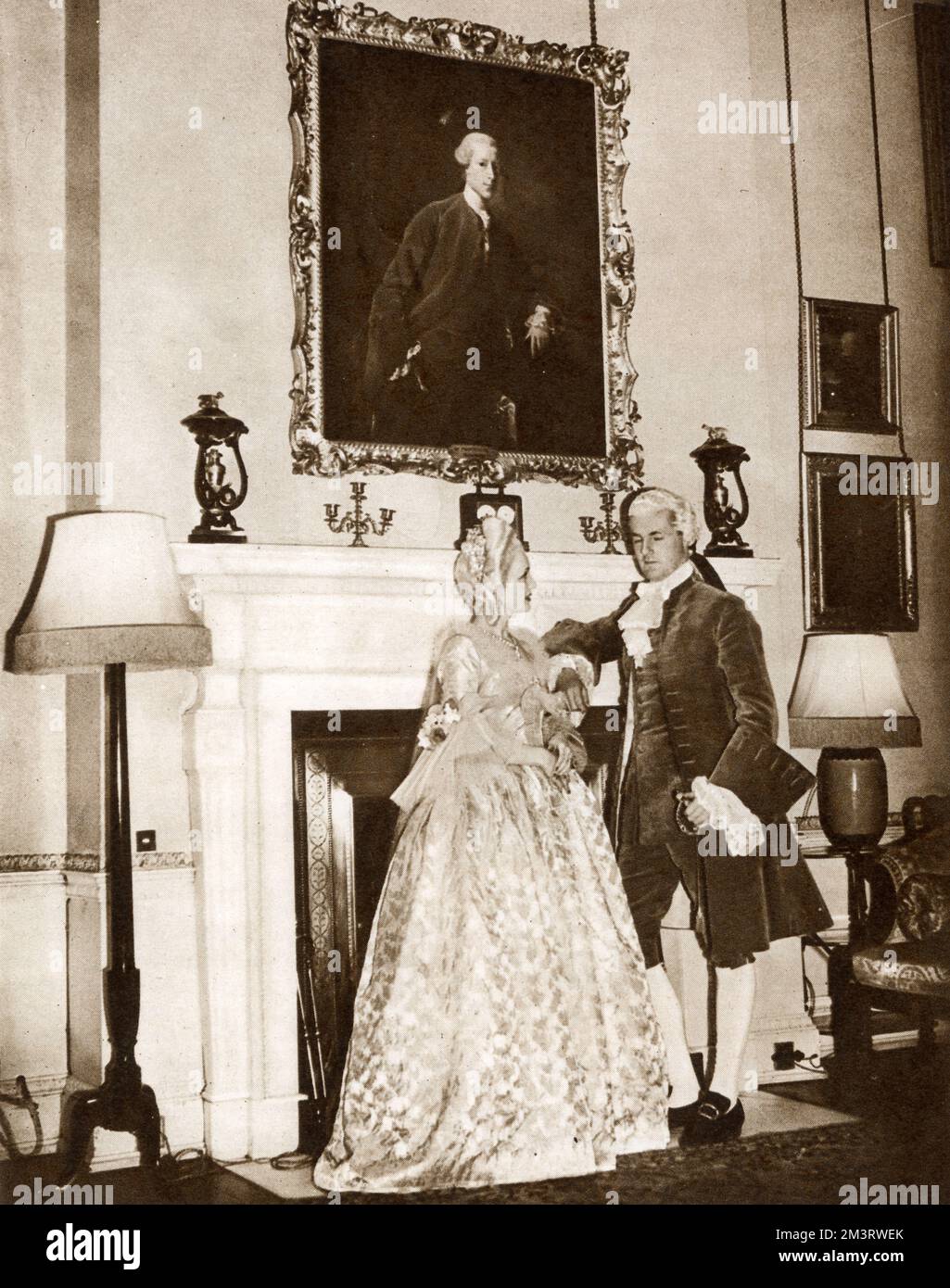 George Child Villiers(1910-1998), 9th Earl of Jersey and his second wife Virginia(1908-1996), the Countess of Jersey. Photographed under the portrait of his ancestor Francis Child at the Georgian Ball, held at Osterley Park in West London. Lord Jersey wore a replica of the costume shown in the painting.     Date: 1939 Stock Photo